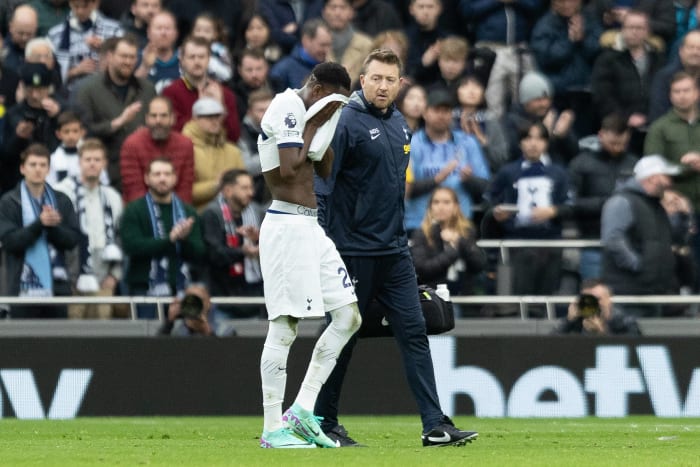 Tottenham Hotspur midfielder Pape Matar Sarr pictured walking off the field with his jersey covering his face after picking up an injury during a Premier League game against Bournemouth on New Year's Eve in December 2023